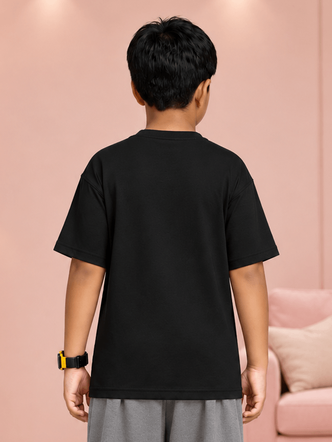 Back view of a child wearing a COOLFIT T-SHIRT FOR BOYS GIRLS BLACK in a stylish setting.