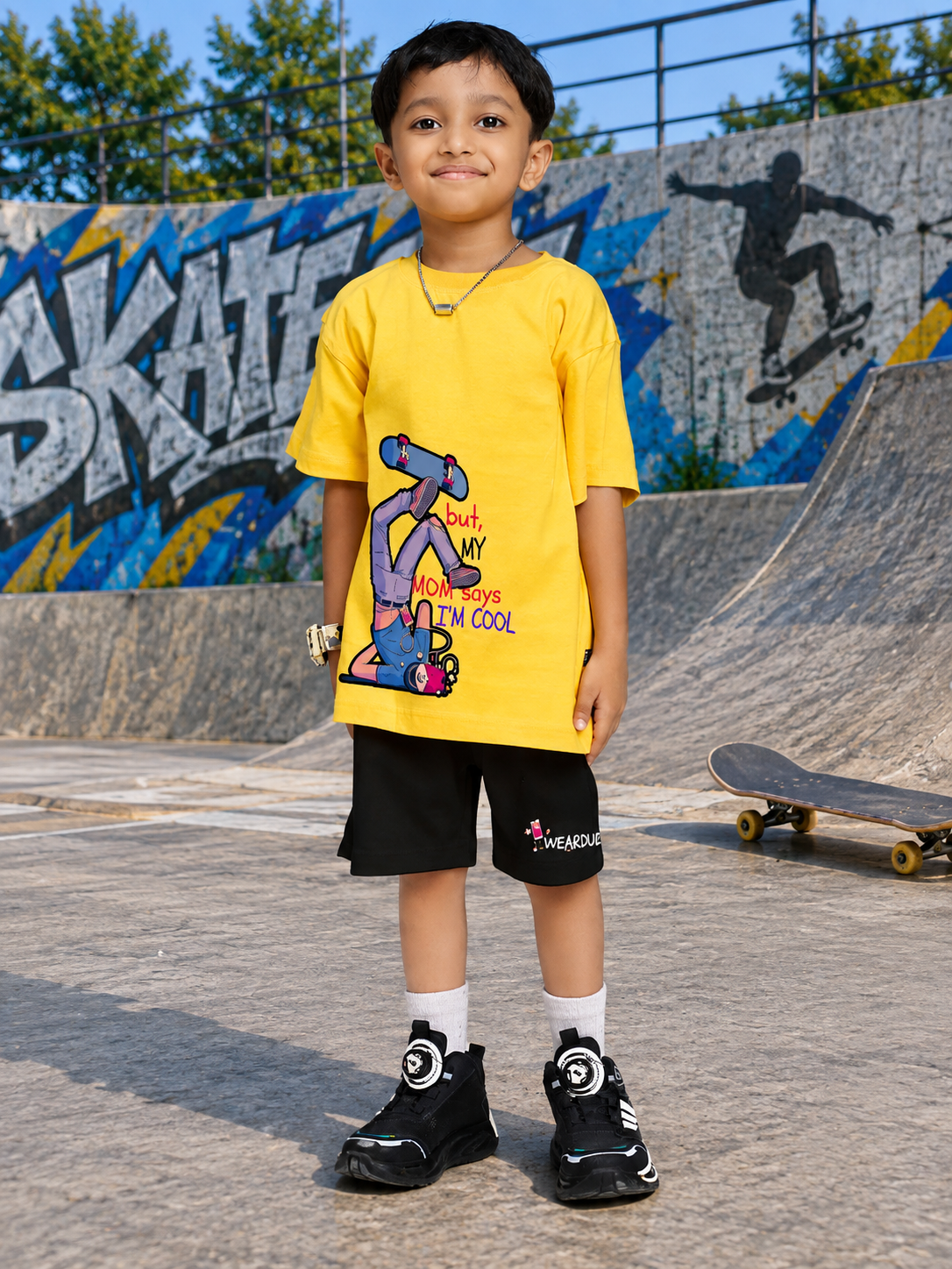 COOL DUDE SKATER CO-ORD FOR BOYS GIRLS BLACK YELLOW BLACK worn by a young boy in a skate park setting.