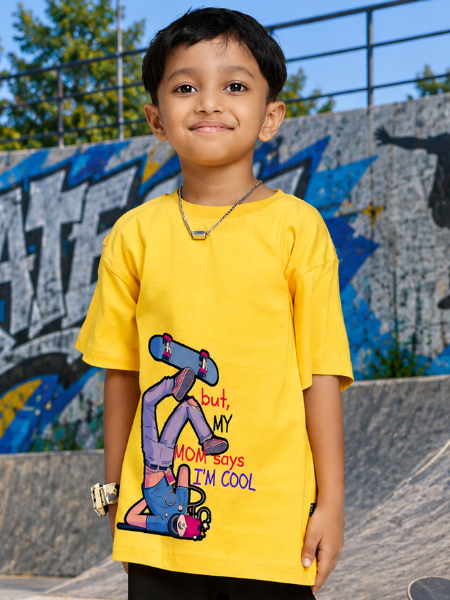 COOL DUDE SKATER T-SHIRT FOR BOYS GIRLS YELLOW worn by a boy with skateboard design, vibrant yellow color, standing at a skatepark.