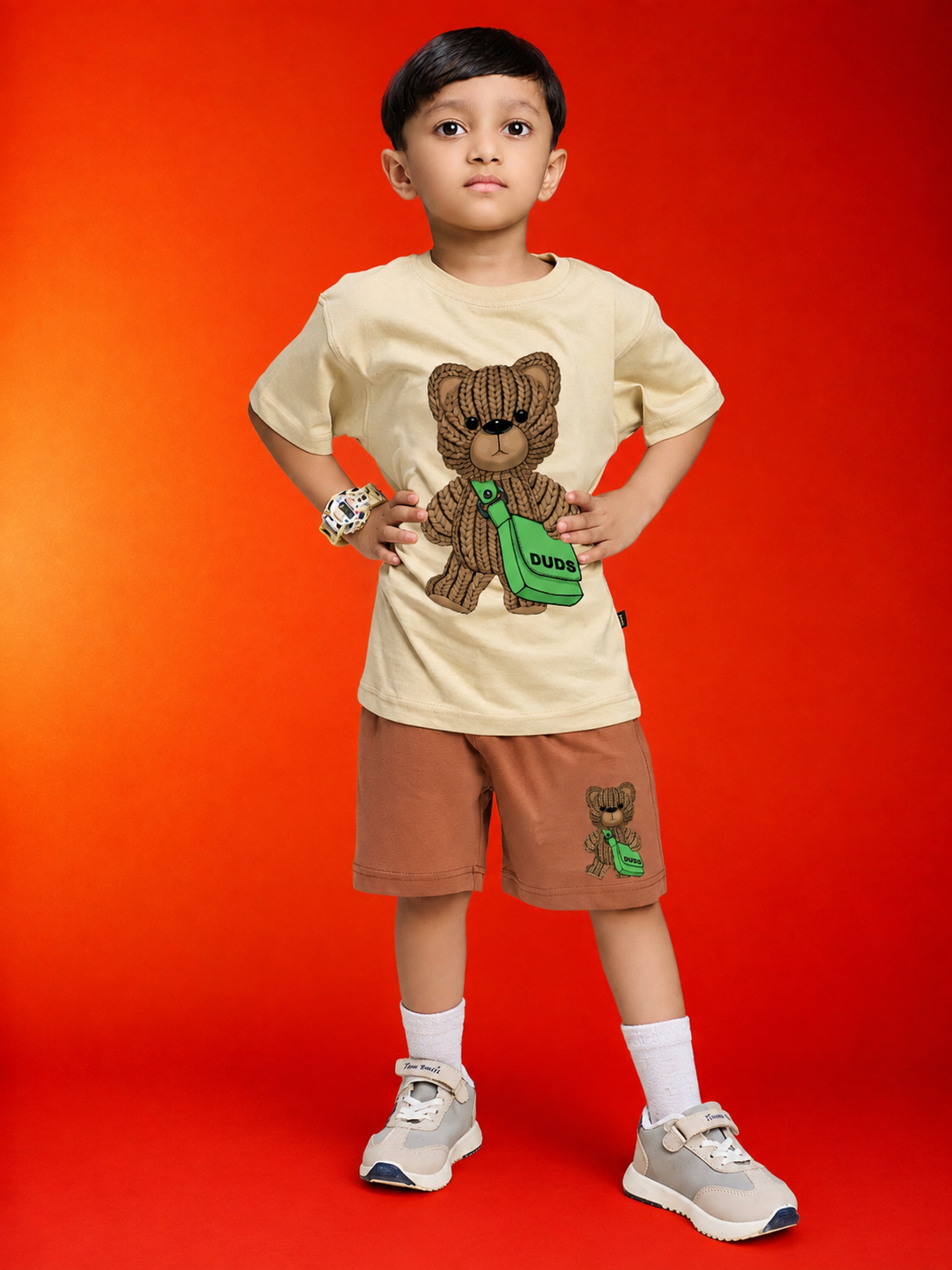 LITTLE EXPLORER TEDDY CO-ORD FOR BOYS GIRLS BEIGE BROWN worn by a boy in a playful pose on a vibrant background.