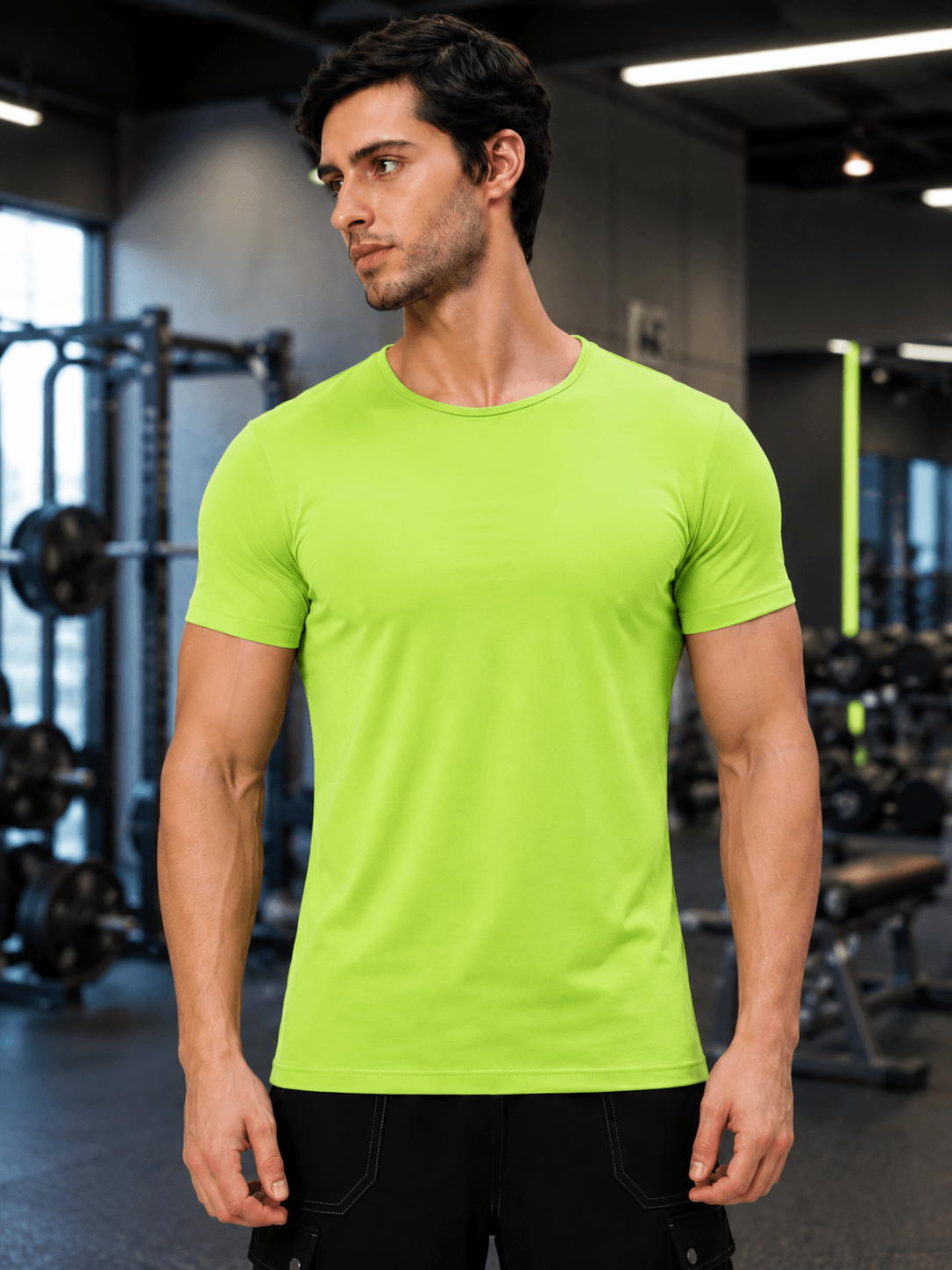 A model wearing a BEDROCK FIT REGULAR FIT T-SHIRT NEON GREEN in a fitness gym setting.