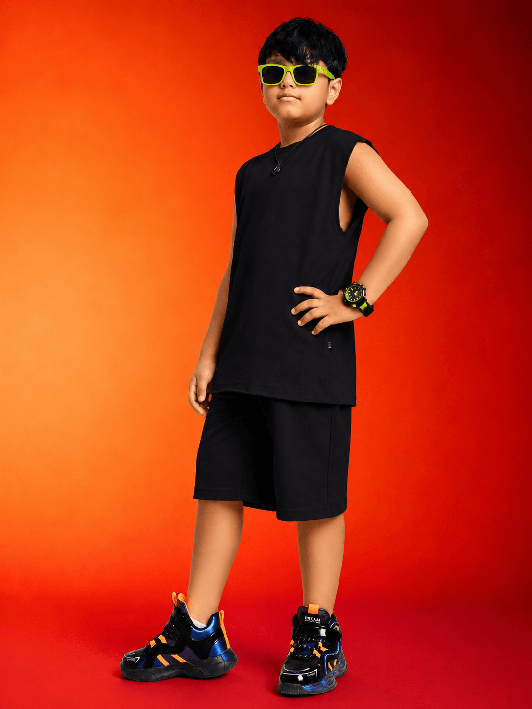 NEON RUSH SLEEVELESS CO-ORD FOR BOYS GIRLS BLACK worn by a confident boy in a sleek black outfit with neon accessories.