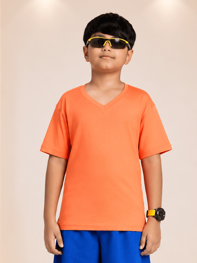 COOLFIT T-SHIRT FOR BOYS GIRLS ORANGE worn by a boy, showcasing its vibrant color and stylish design.