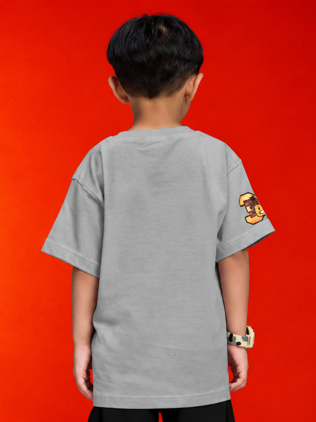 Back view of a boy wearing a ROBLOX WORLD FIT T-SHIRT FOR BOYS GIRLS GREY against a vibrant red background.