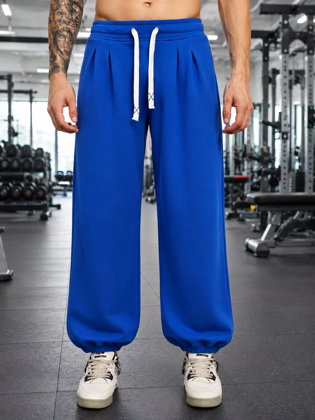 Model wearing COOLFIT BAGGY LOOSE FIT JOGGER BLUE in a gym setting, showcasing relaxed fit and vibrant color.