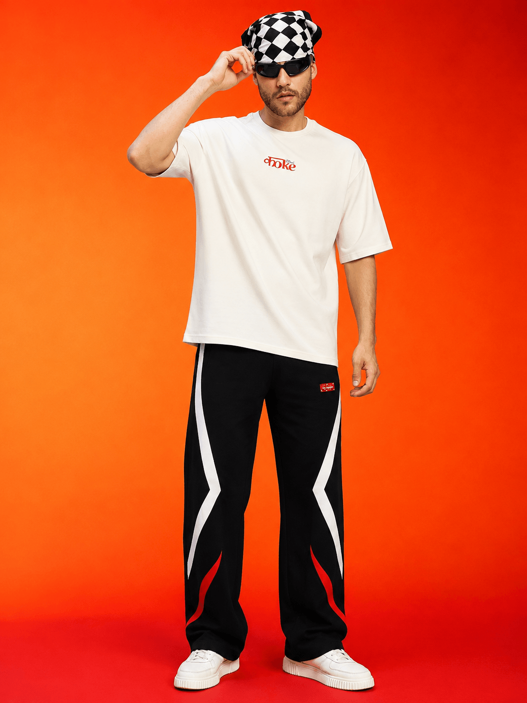 Man wearing METROPOLITAN CONTRAST GRAPHIC JOGGERS BLACK MULTI with graphic tee and checkered bandana.