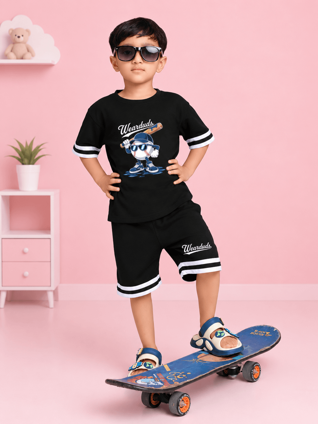 MASCOT GRAPHIC T-SHIRT FOR BOYS GIRLS BLACK WHITE modeled by a kid on a skateboard with sunglasses.