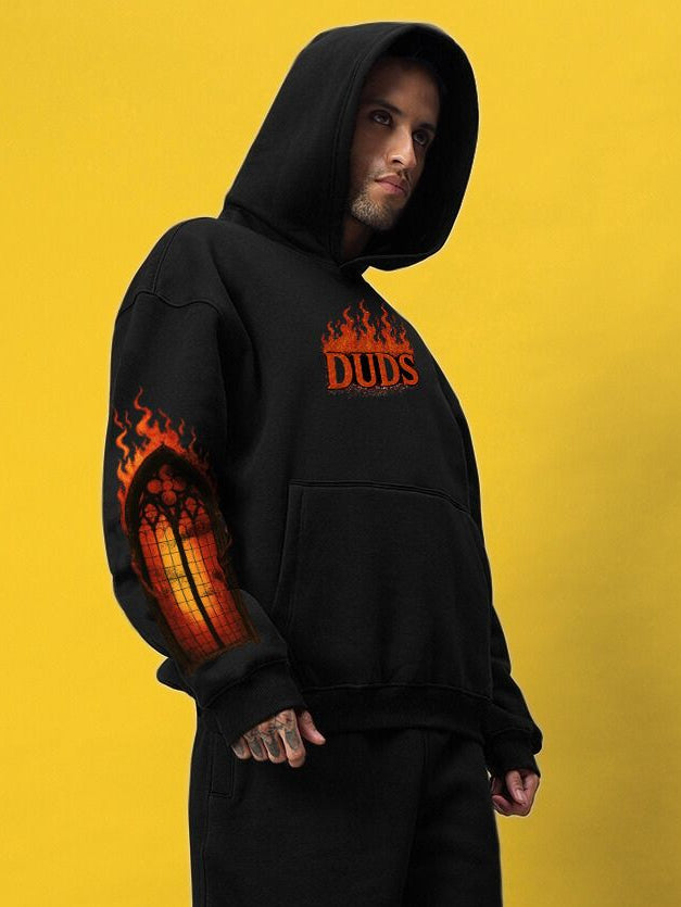 FIRE NEVER KILLS THE LIGHT PRINTED FLEECE HOODIE BLACK on model, showcasing street-style with graphic design and warmth.