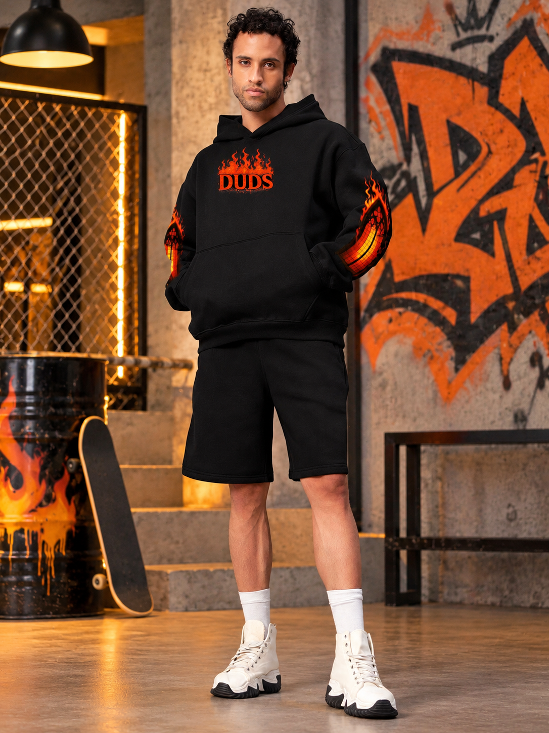 Man wearing FIRE NEVER KILLS THE LIGHT FLEECE CO-ORD BLACK hoodie and shorts set with flame graphic design