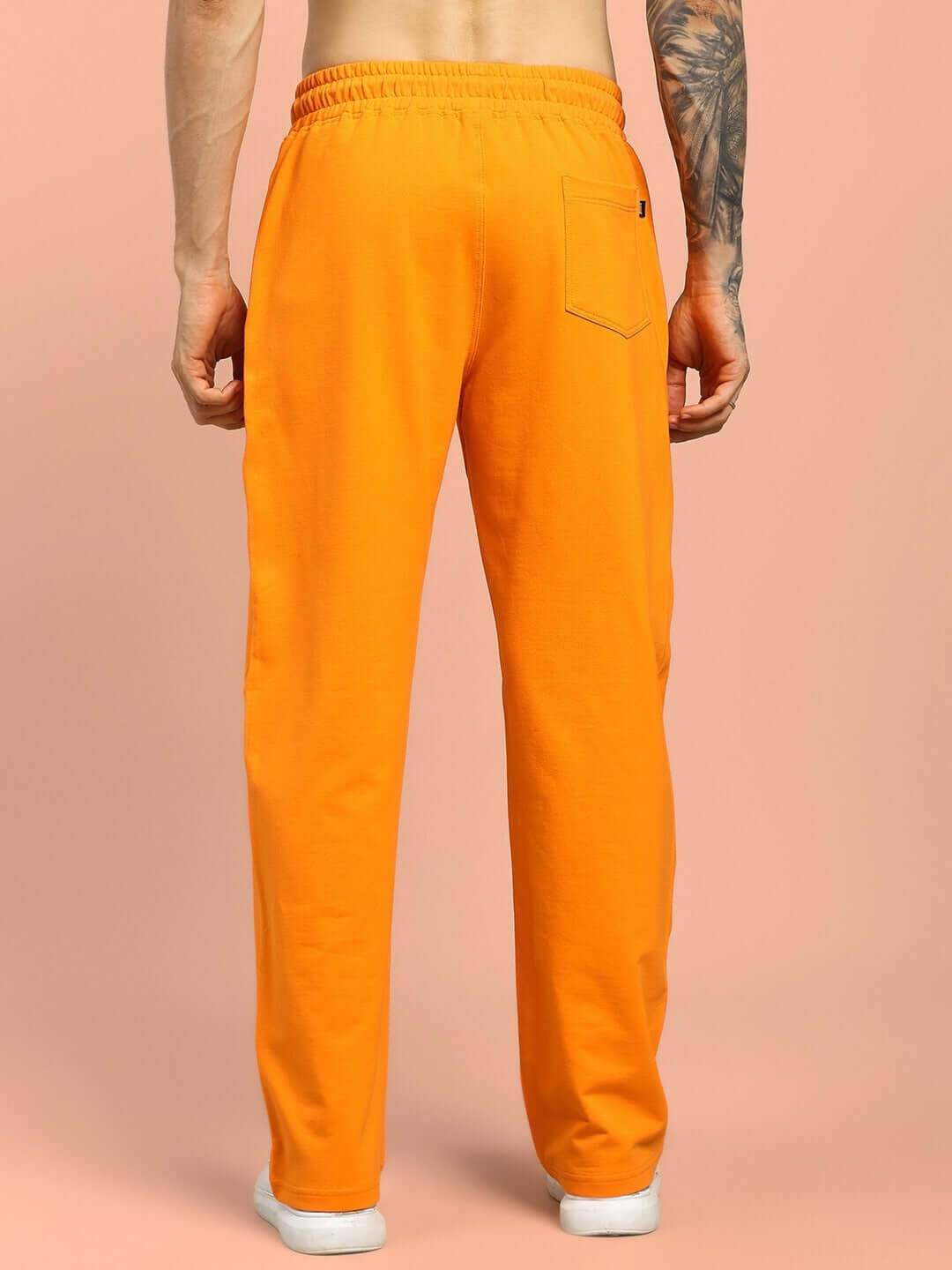 Back view of FLAMING SKELETON PRINTED RELAXED FIT JOGGER ORANGE worn by a model.