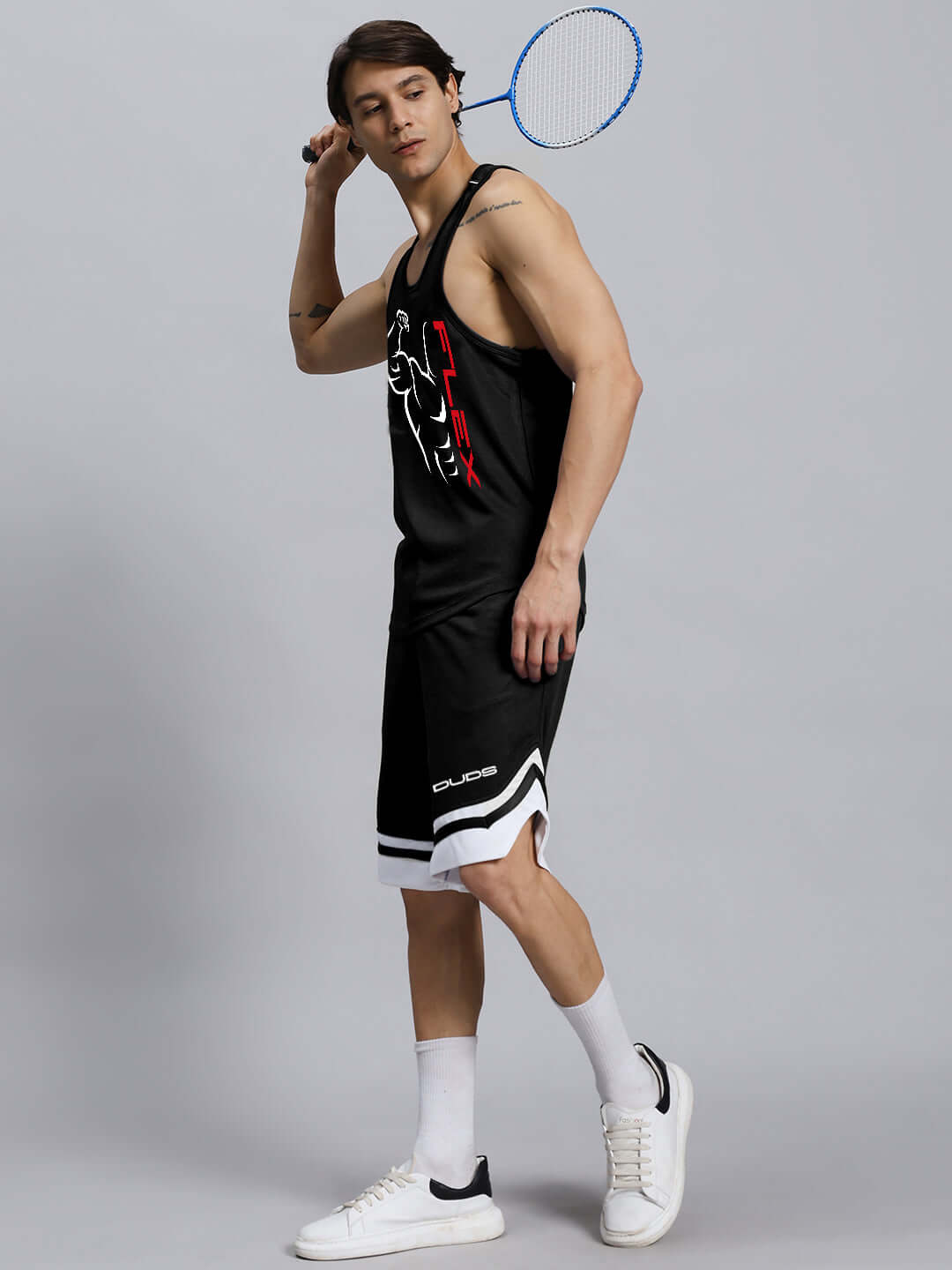 Man wearing FLEX GYM SLEEVELESS CO-ORD SET BLACK, holding a badminton racket.