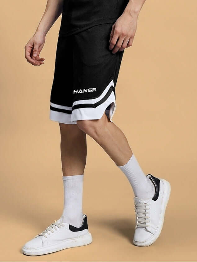 Person wearing FLEX REGULAR FIT COTTON SHORTS BLACK with white sneakers, showcasing casual style.