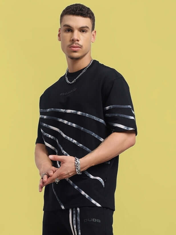 Model wearing Flicker Designer Oversized T-Shirt in black with silver stripe design, made from premium cotton blend, suitable for casual wear.