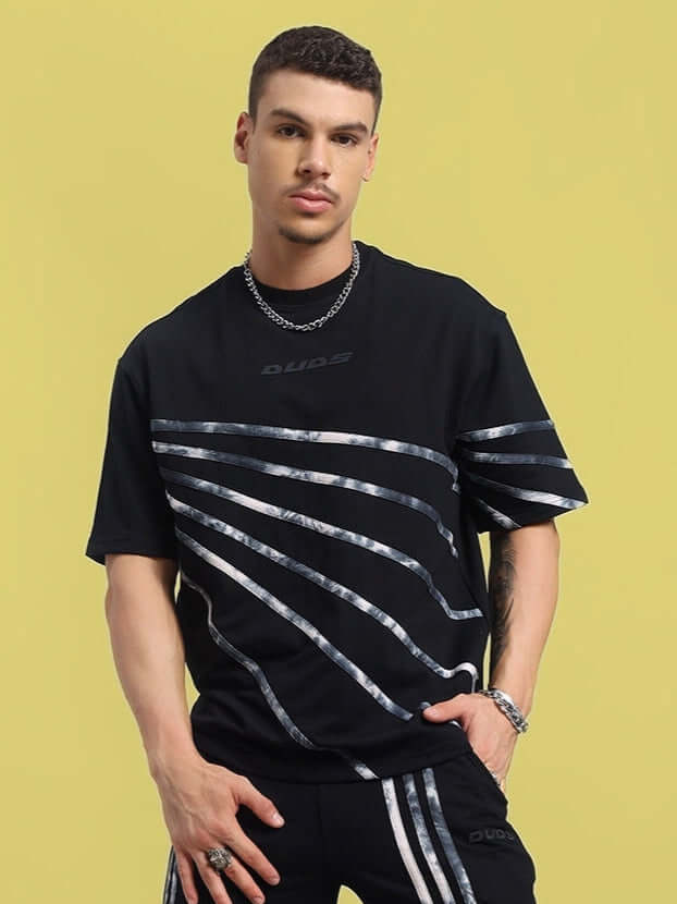 Model wearing Flicker Designer Black Oversized T-Shirt in premium cotton with silver stripe details; perfect for stylish casual wear.