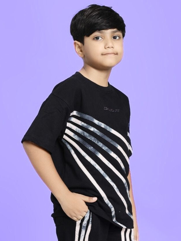 Boy wearing FLICKER DESIGNER OVERSIZED T-SHIRT FOR BOYS AND GIRLS BLACK with stripes, posing against a purple background.