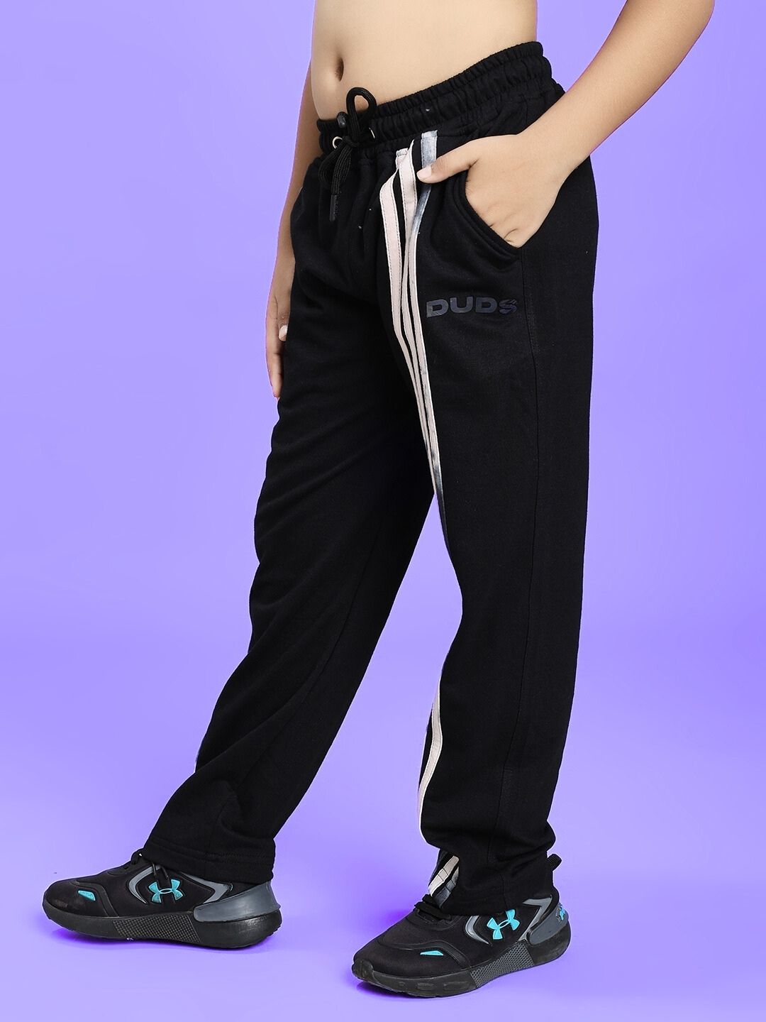 Child wearing black FLICKER JOGGER FOR BOYS AND GIRLS BLACK with sneakers, emphasized casual style and comfort.