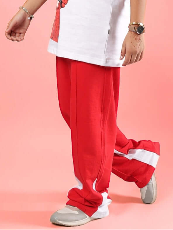 Child wearing red floppy jogger pants with white accents, designed for boys and girls by DUDS, available with custom fit options.