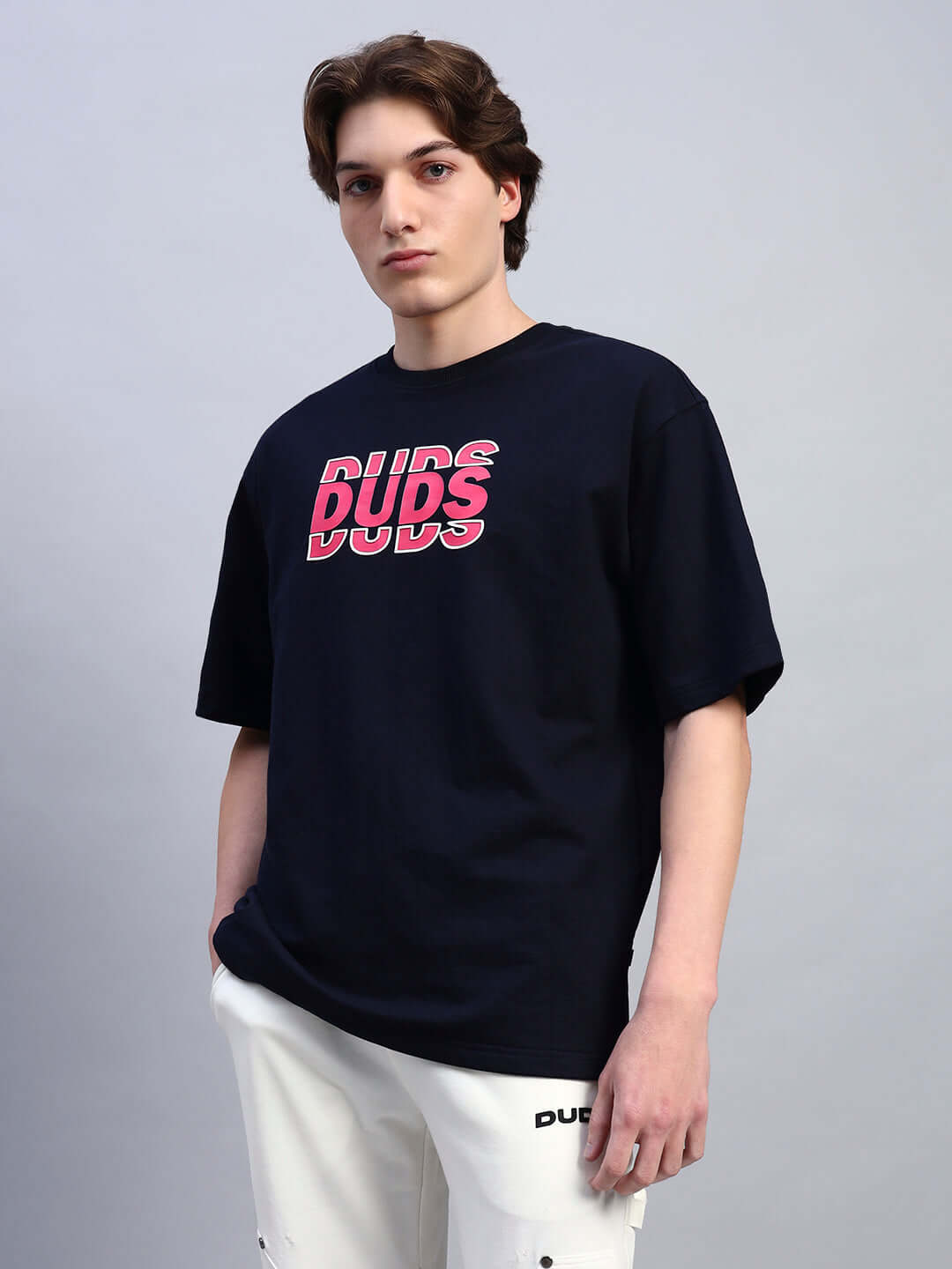 Man wearing FLORES CREATIVE PRINT OVERSIZED T-SHIRT NAVY BLUE showcasing artistic design and relaxed fit.