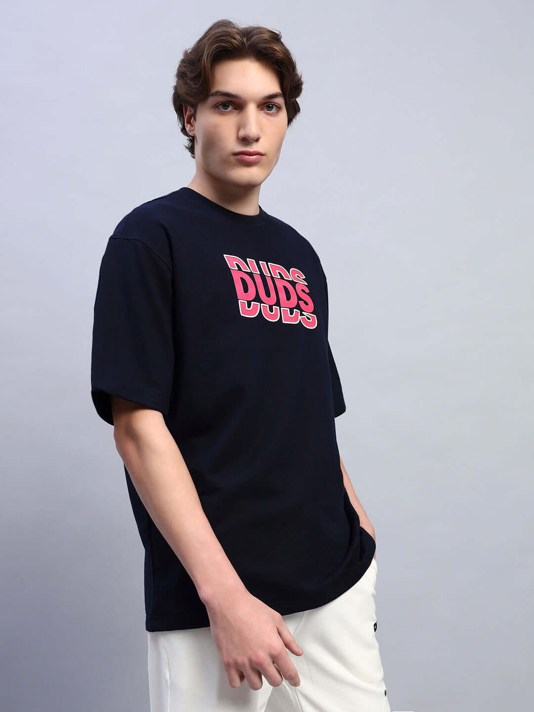 Man wearing FLORES CREATIVE PRINT OVERSIZED T-SHIRT NAVY BLUE with artistic print.