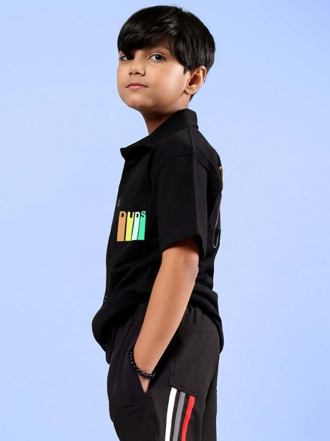 Boy wearing a black FOREVER GAMER shirt, stylish casual wear for kids, from DUDS made-to-order collection.