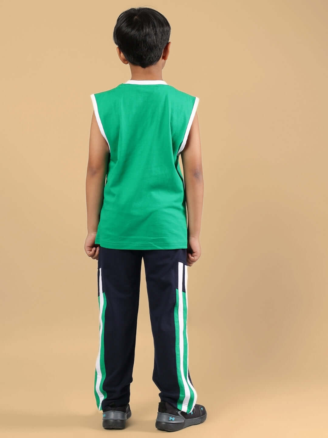 Back view of child wearing FORZA CO-ORD FOR BOYS & GIRLS NAVY-GREEN, showcasing green top and navy pants with green stripes.