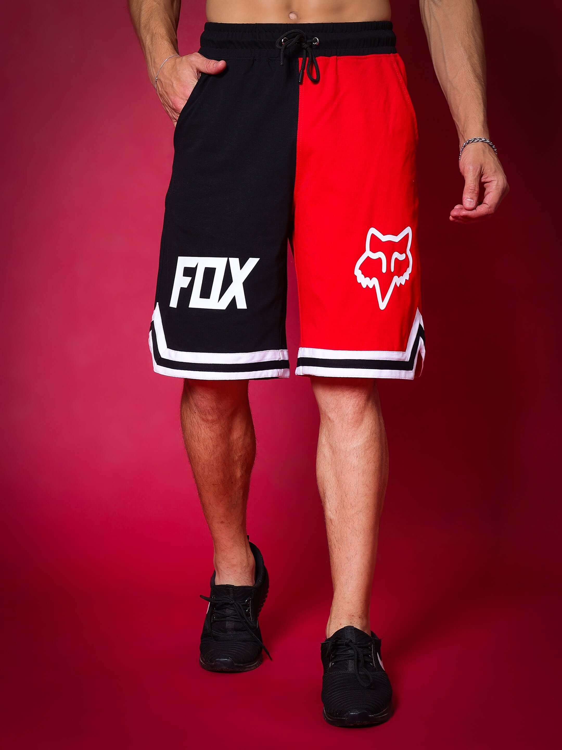 Fox regular fit red-black shorts with logos, ideal for customization, shown on a model against a vibrant backdrop.