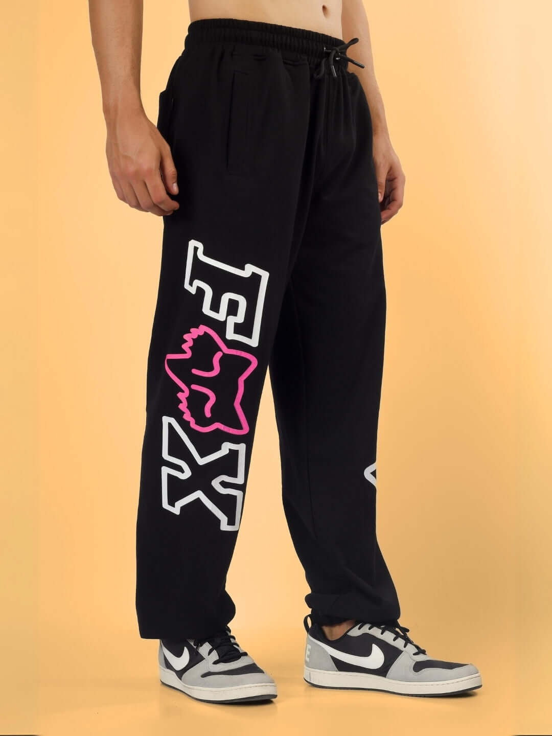 Model wearing Fox Relaxed Jogger in black, featuring bold logo design, tailored to order, displayed against a neutral background.