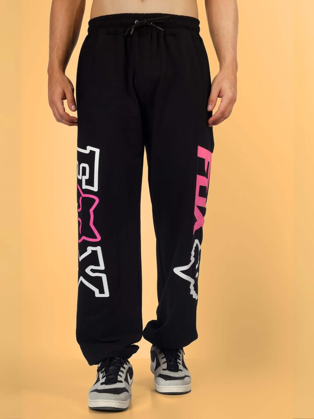 Man wearing FOX Relaxed Jogger in black with bold graphics, highlighting comfortable design ideal for casual wear