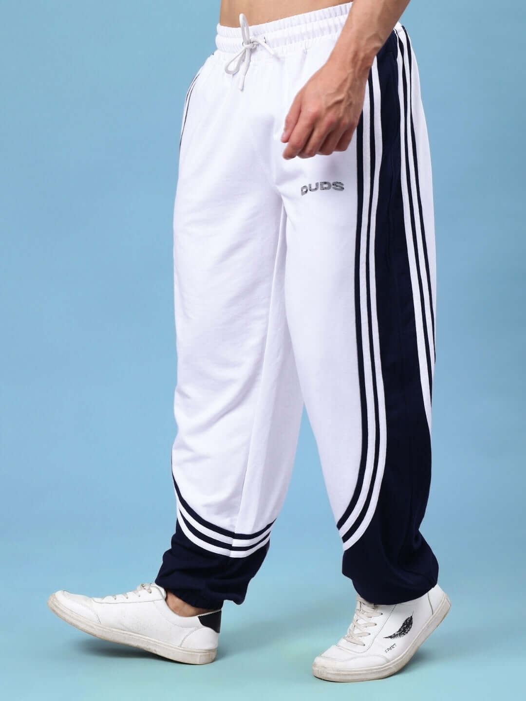 Man wearing white navy contrast joggers from DUDS, showcasing side stripes and custom fit option.