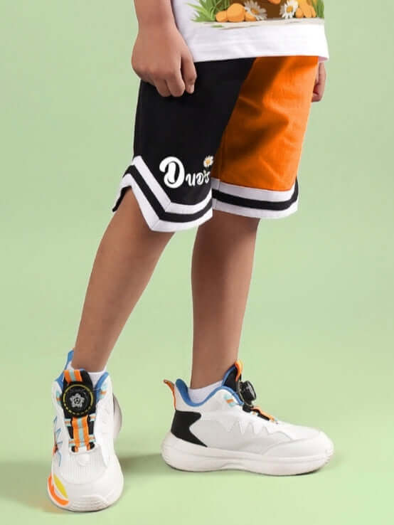 FRIENDSHIP BUCKET SHORTS FOR BOYS & GIRLS BLACK-ORANGE displayed with stylish sneakers.