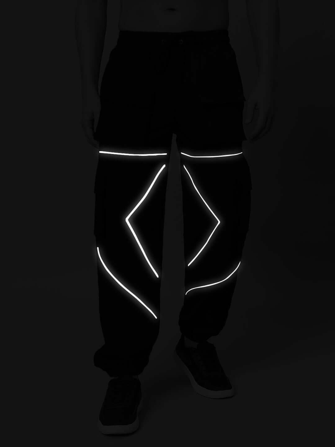 Black parachute cargo pants with reflective detailing on legs, offering customizable fit options for unique style and comfort.