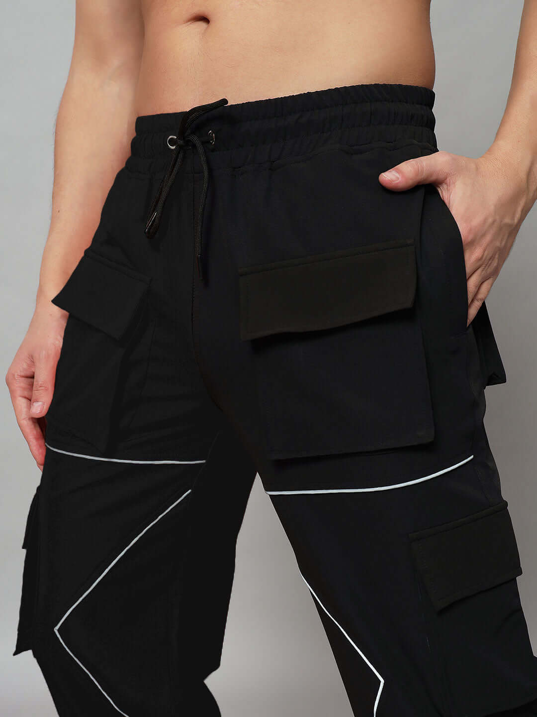 Close-up of FRONTLINE REFLECTOR PARACHUTE CARGO PANT BLACK with reflective accents and cargo pockets.