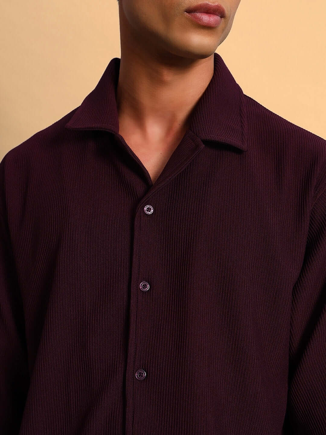 Close-up of FROWZY wine-colored solid shirt with half sleeves and ribbed texture, showcasing button details and a curved hem design.