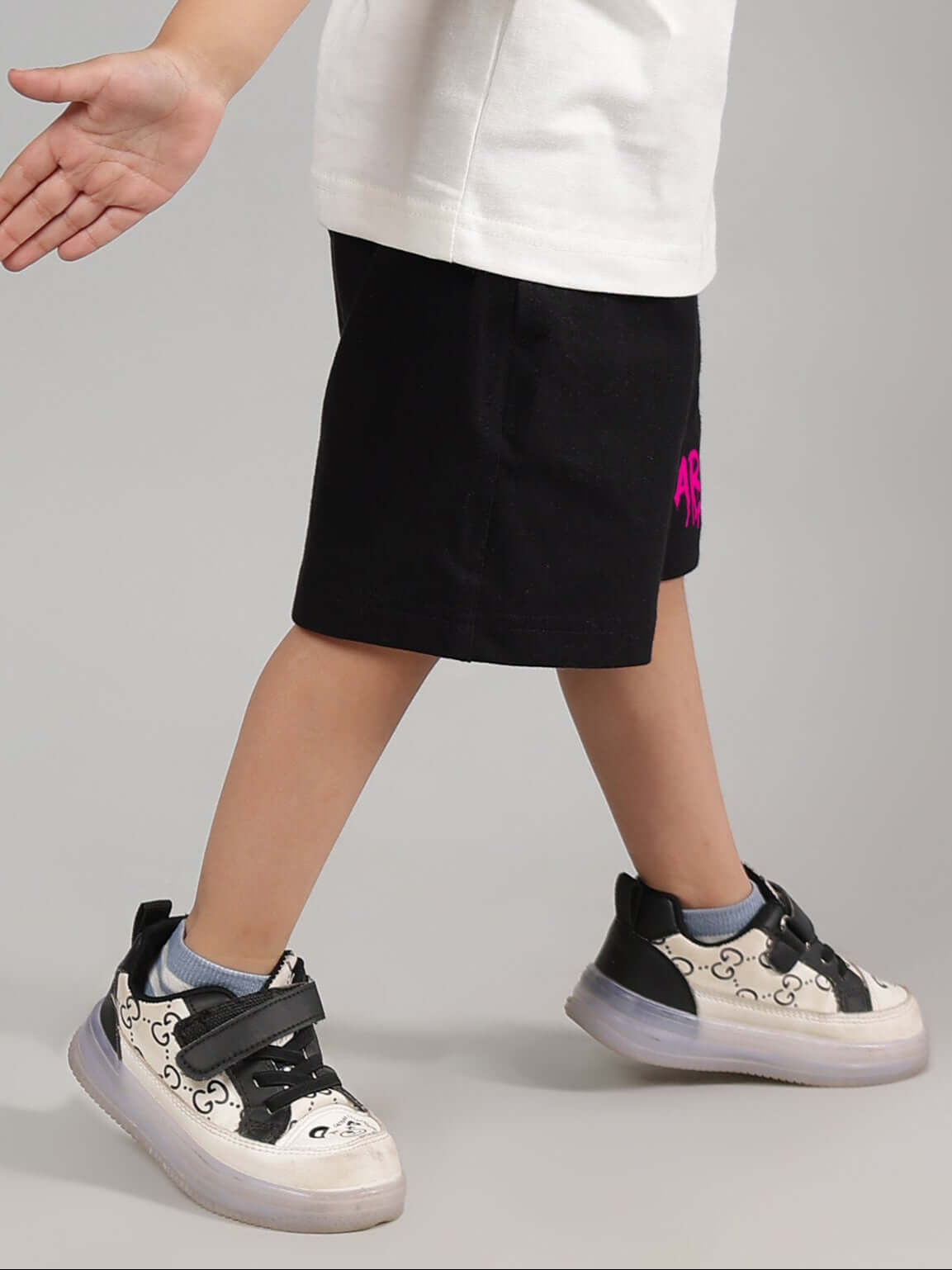 Child wearing black summer shorts with printed design, custom fit options available, by DUDS.