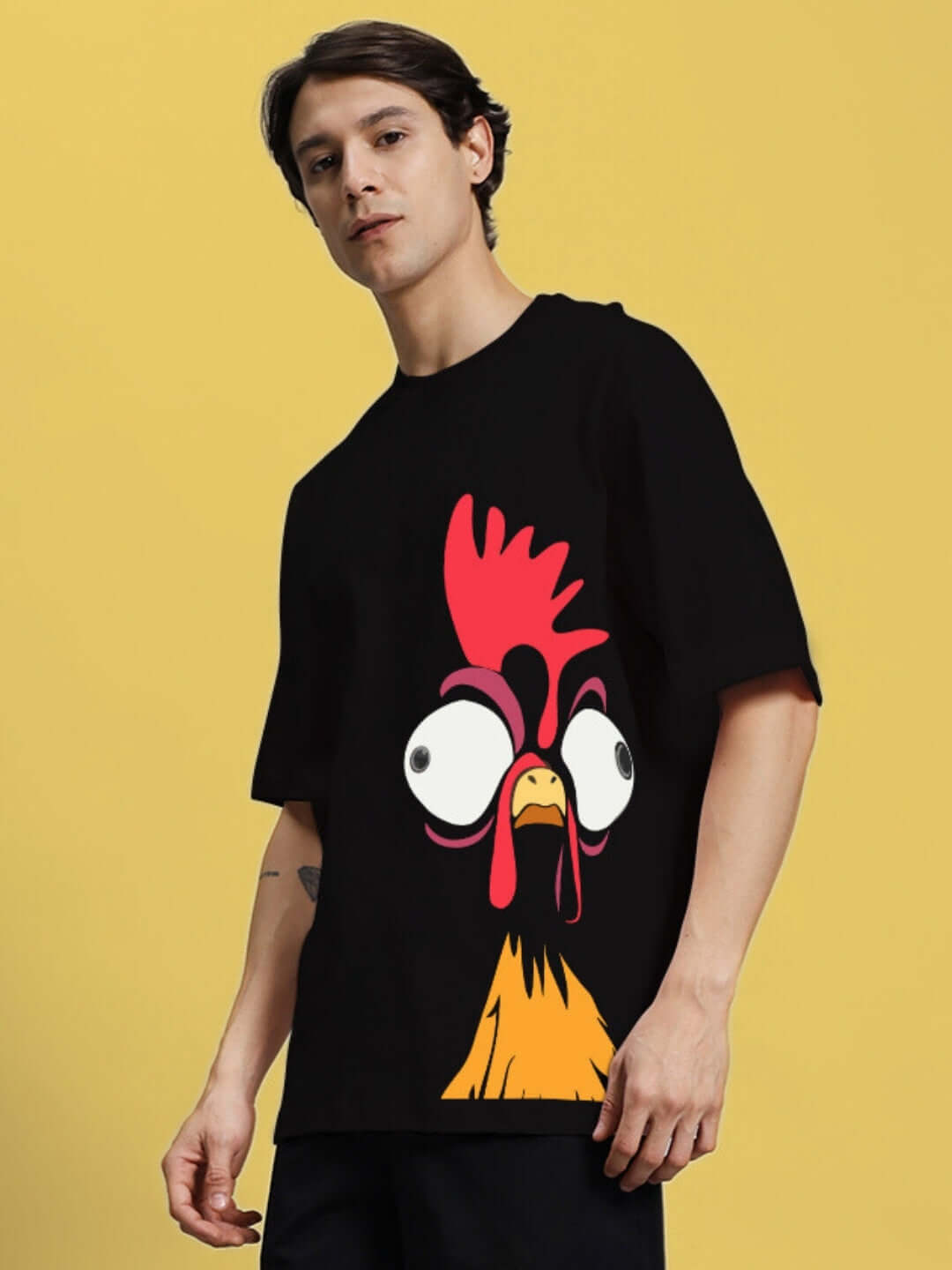 Model wearing a black oversized t-shirt with a humorous chicken print, made from 100% cotton, 200 GSM bio-washed fabric.