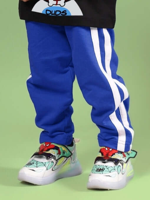 Child wearing FUTURE ICON JOGGER FOR BOYS & GIRLS BLUE with colorful sneakers.