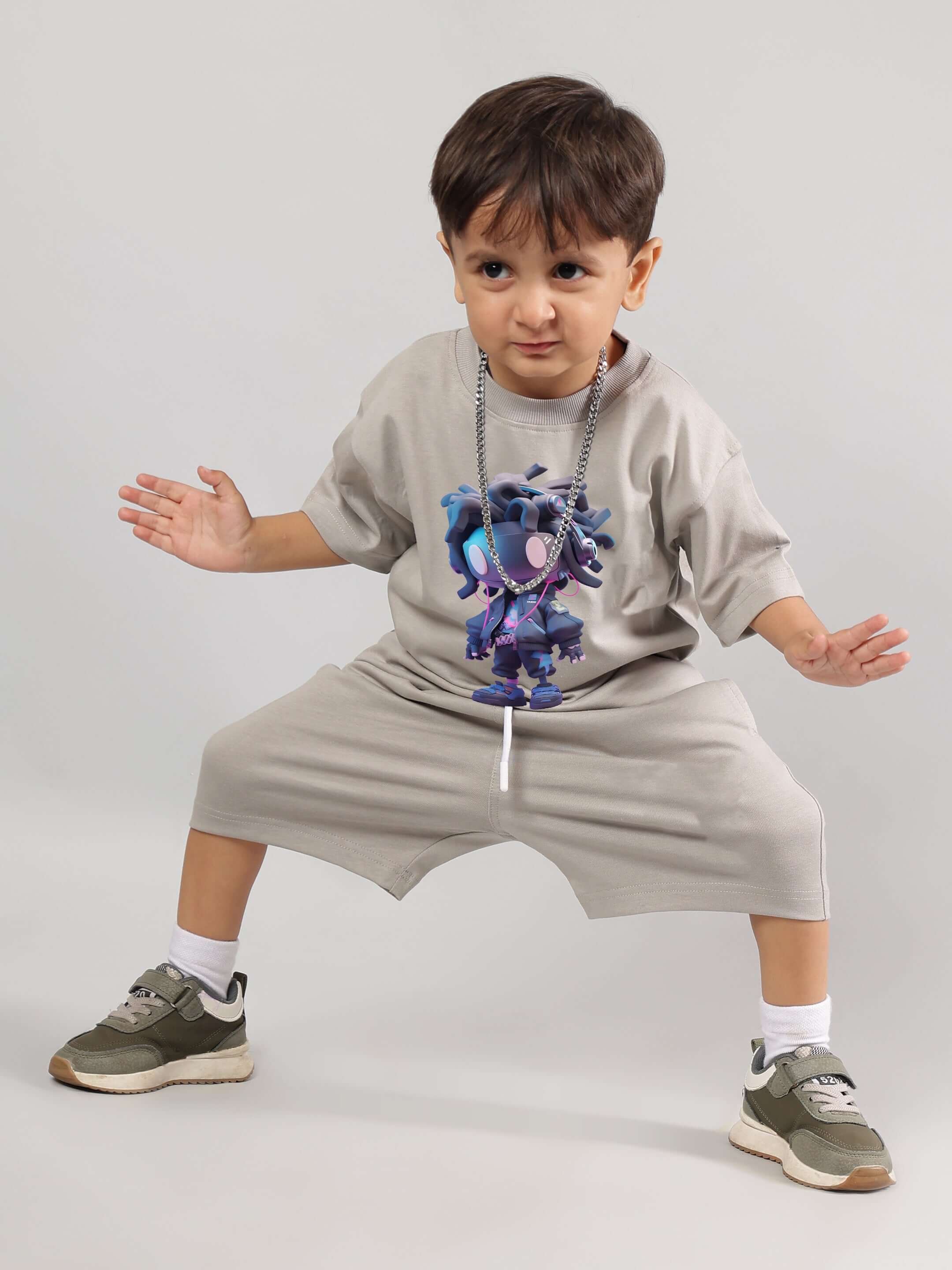 Child wearing FUTURISTIC KIDS CO-ORD (GREY) standing in playful pose with graphic tee and shorts.