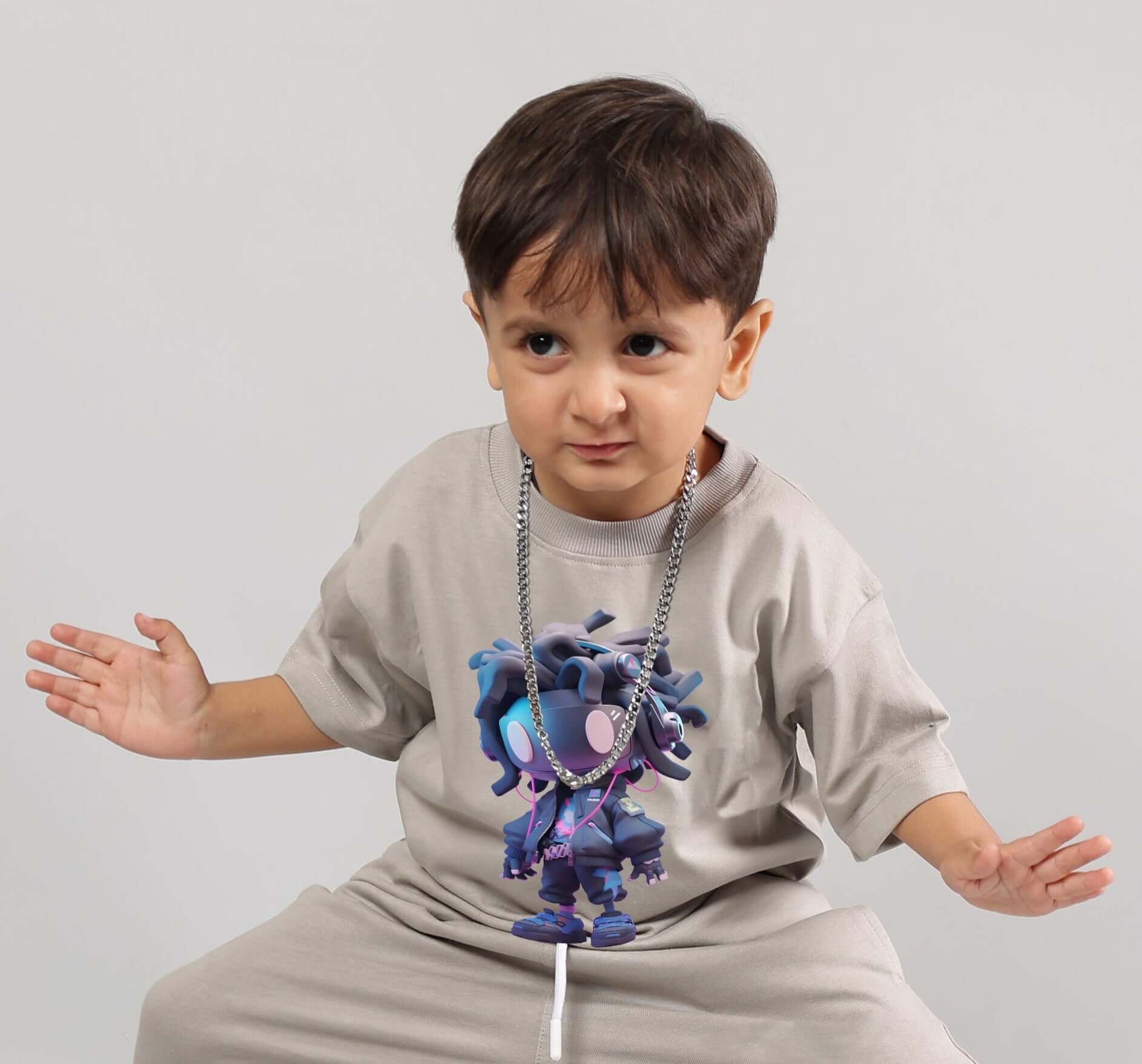 Child wearing a grey futuristic kids t-shirt with bold tech-inspired graphic, showcasing modern design and playful energy.