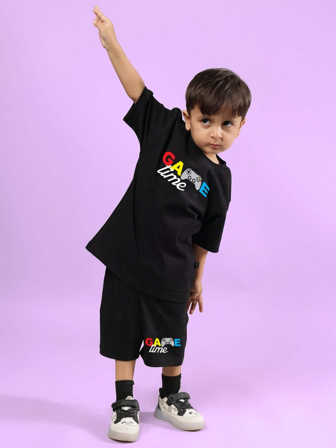 Young child wearing black Game Finisher co-ord set for boys & girls, featuring colorful lettering on a purple background.
