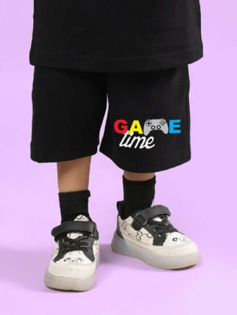 GAME FINISHER SHORTS FOR BOYS & GIRLS BLACK featuring colorful 'Game Time' print, displayed on a child wearing sneakers.