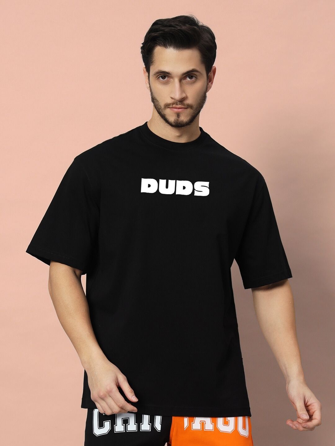 Man wearing GAME-OVER OVER-SIZED T-SHIRT BLACK, featuring bold text design on the front.