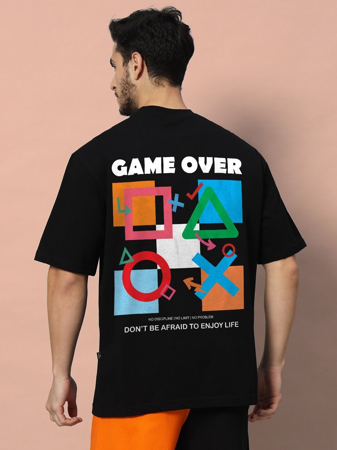 Back view of man wearing GAME-OVER OVER-SIZED T-SHIRT BLACK with graphic design.
