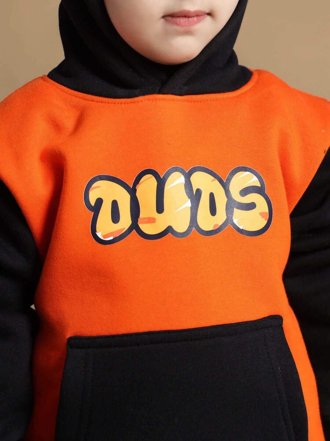 Child wearing Garfield-themed black and orange hoodie with "DUOS" text design on the front.