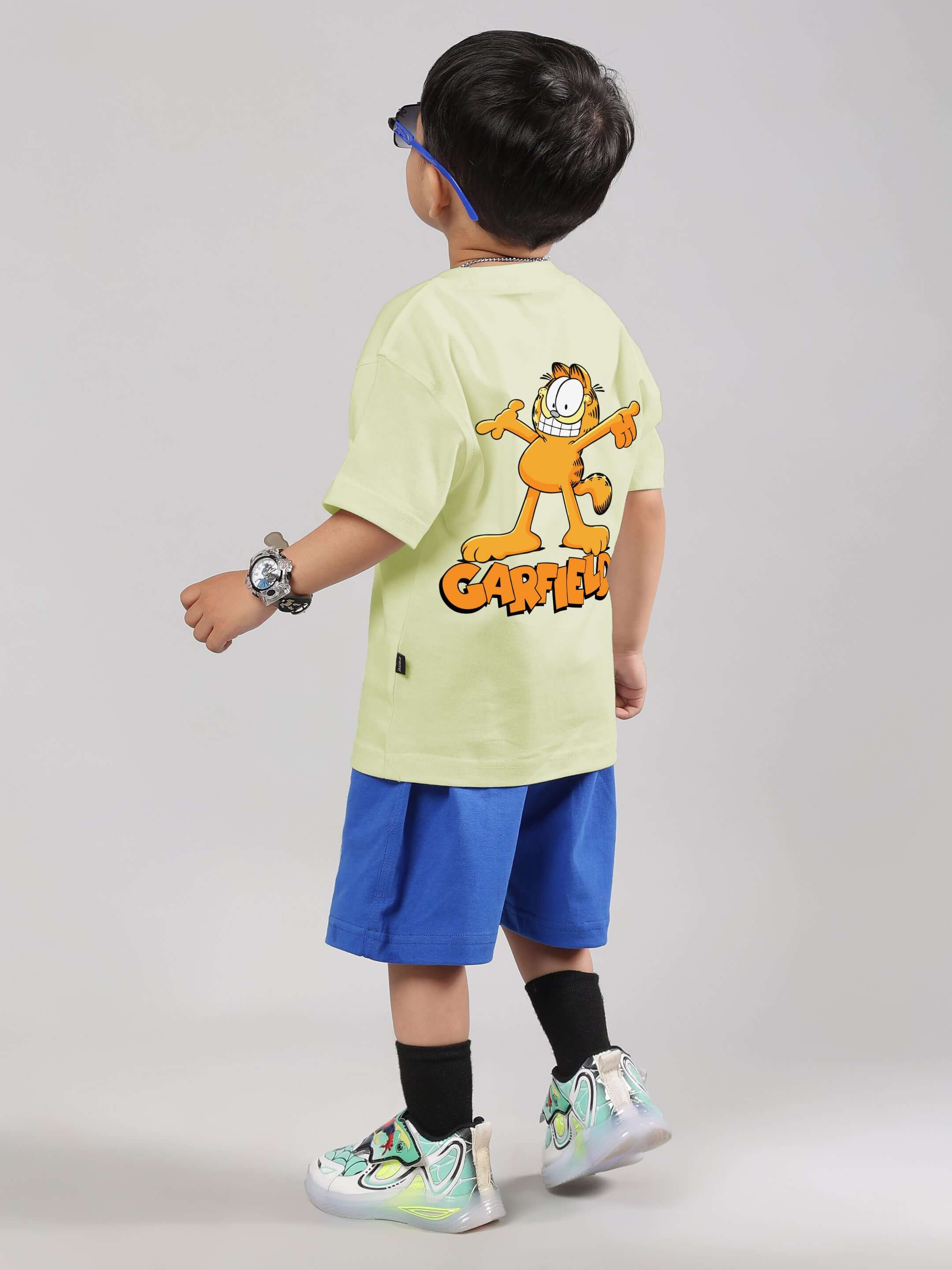 Child wearing celery-ice-blue Garfield co-ord set, featuring a graphic t-shirt and shorts, designed by DUDS.