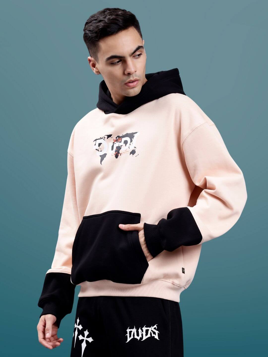 Model wearing Generation Duds Fleece Colorblock Oversize Hoodie in urban streetwear style against a minimalist background.