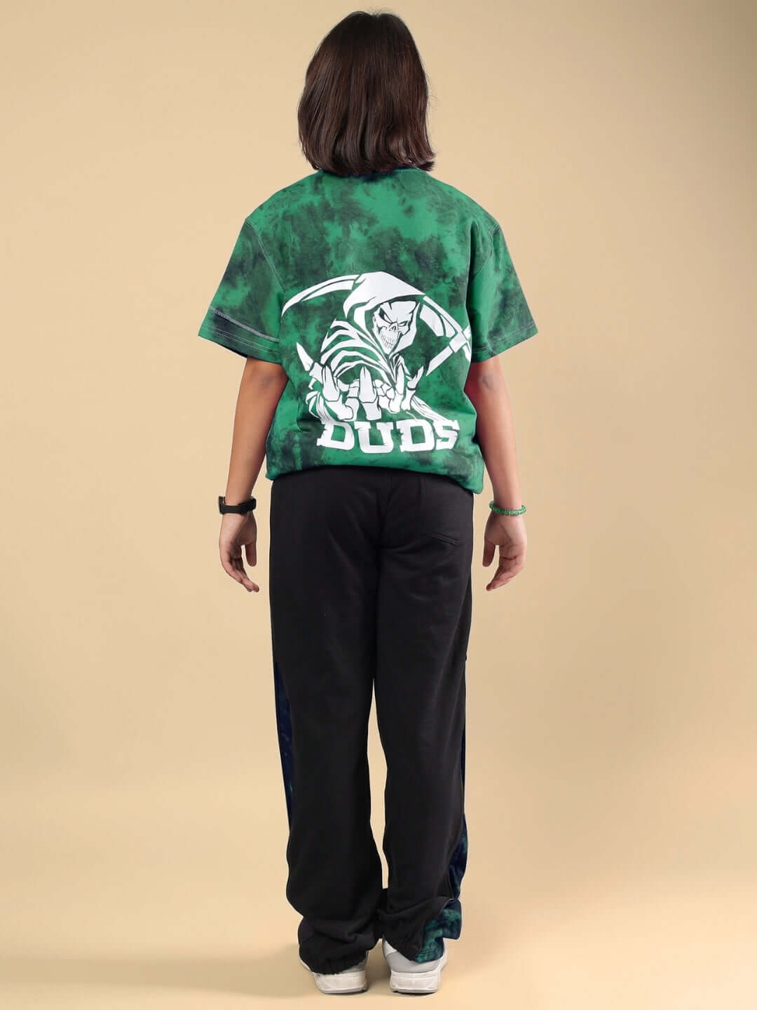Child wearing GHOST RIDER CO-ORD FOR BOYS & GIRLS GREEN BLACK from DUDS, featuring a green top with ghost design. Made to order attire.
