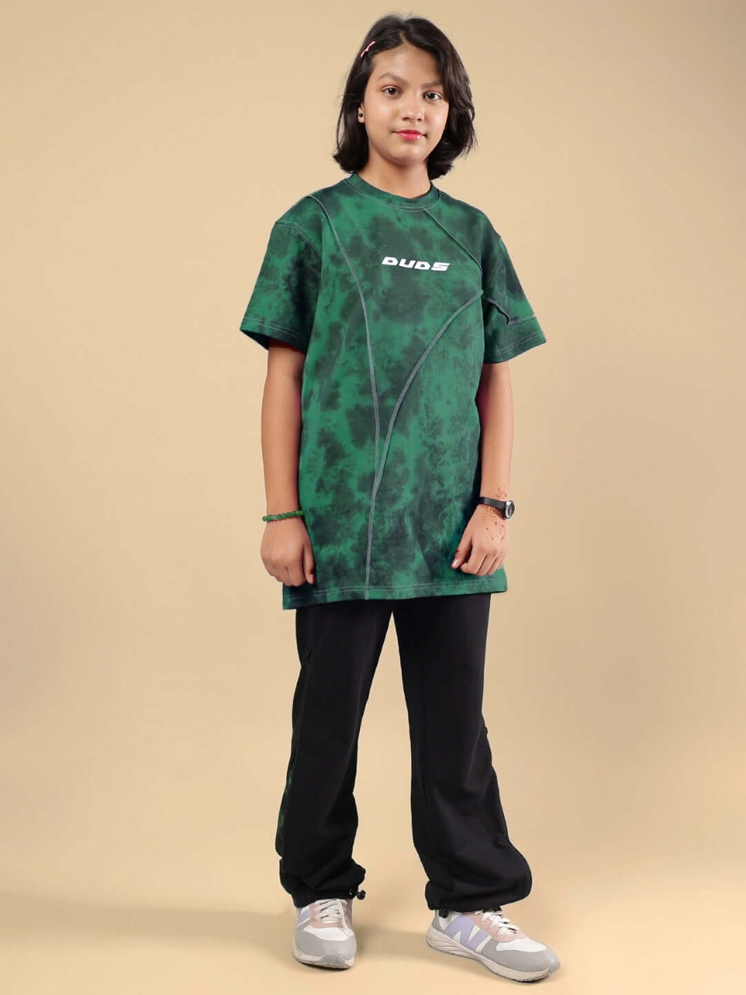 Child wearing GHOST RIDER CO-ORD FOR BOYS & GIRLS GREEN BLACK set by Duds, featuring green top and black pants, front view.