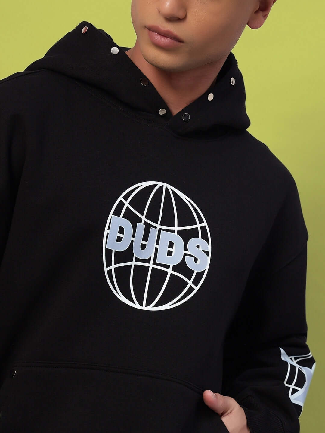 Person wearing GLOBAL COTTON FLEECE CO-ORD BLACK hoodie with logo, showcasing urban streetwear style and premium cotton fleece material.