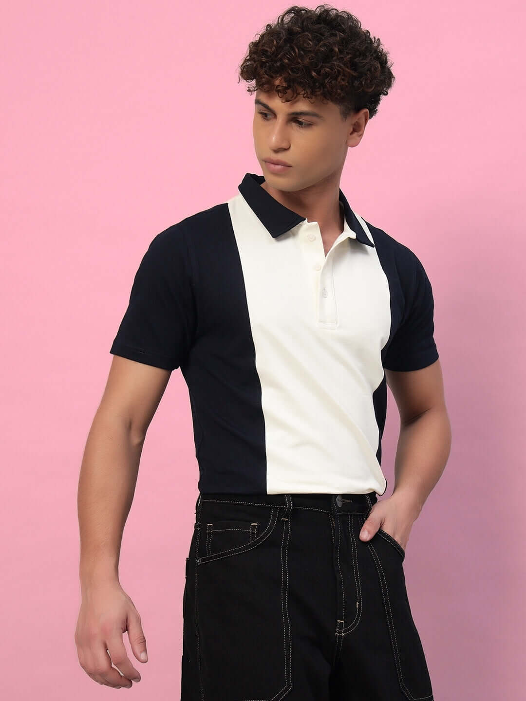 Model wearing navy-blue GLORY regular fit T-shirt made of premium cotton with contrasting panels, against a pink background.