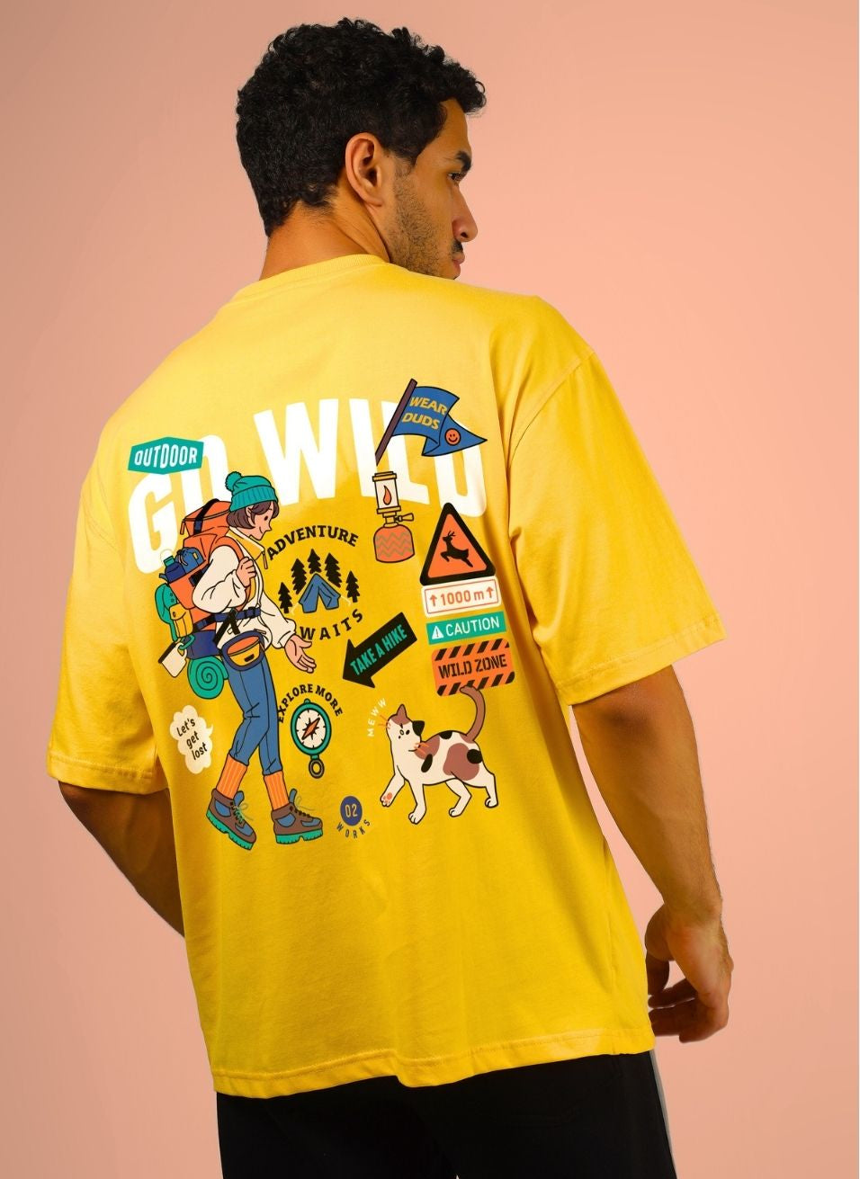 GO WILD ADVENTURE OVER-SIZED T-SHIRT YELLOW with colorful graphics of outdoor adventures on the back, worn by a male model.